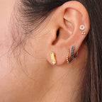 A pair of gold plated classic sterling silver stud earrings, each crafted in the shape of a petite, elegant ballet slipper. A single, brilliant cubic zirconia is set at top of the shoe, acting as a sparkling focal point. These dainty studs offer a subtle and refined nod to ballet, perfect for everyday wear. Designed by Royal Academy of Dance. Made in the UK. 