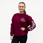 Burgundy sweatshirt with the white 'DANCE' printed on the left arm and the 'Royal Academy of Dance' logo on the left chest.