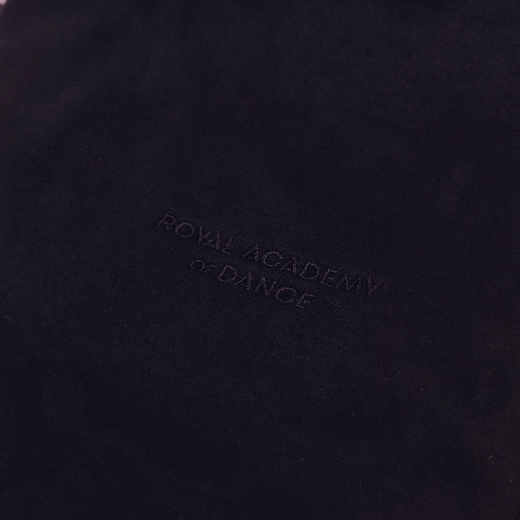 Black jogger with embroidered " Royal Academy of Dance" logo close up 