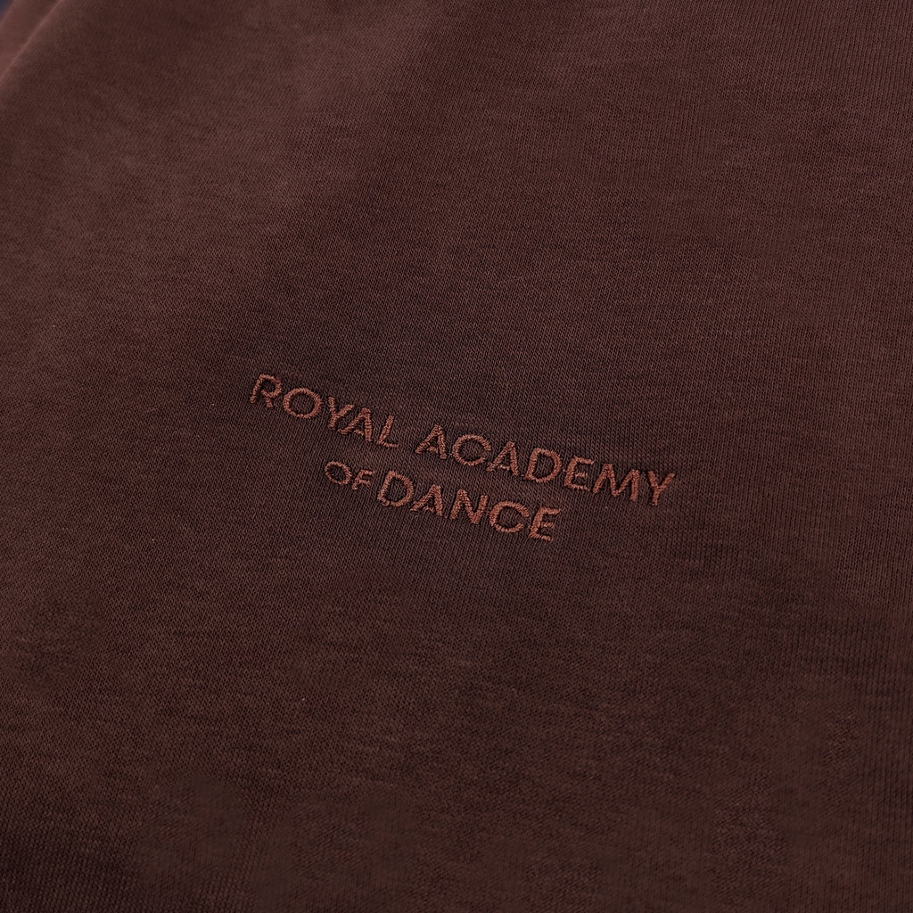 Brown jogger with embroidered " Royal Academy of Dance" logo close up 