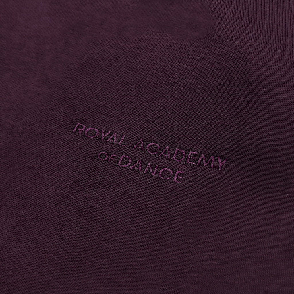 Purple jogger with embroidered " Royal Academy of Dance" logo close up