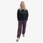Person wearing a black hoodie with 'Royal Academy of Dance' logo in white and purple jogger pants