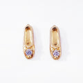 A pair of gold plated classic sterling silver stud earrings, each crafted in the shape of a petite, elegant ballet slipper. A single, brilliant cubic zirconia is set at top of the shoe, acting as a sparkling focal point. These dainty studs offer a subtle and refined nod to ballet, perfect for everyday wear. Designed by Royal Academy of Dance. Made in the UK. 