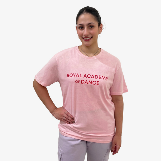 Woman wearing a pink 'Royal Academy of Dance' t-shirt 