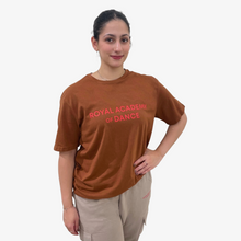  Person wearing a brown 'Royal Academy of Dance' t-shirt 