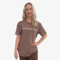 Woman wearing a brown t-shirt with 'Royal Academy of Dance' logo in white