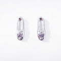 A pair of classic sterling silver stud earrings, each crafted in the shape of a petite, elegant ballet slipper. A single, brilliant cubic zirconia is set at top of the shoe, acting as a sparkling focal point. These dainty studs offer a subtle and refined nod to ballet, perfect for everyday wear. Designed by Royal Academy of Dance. Made in the UK.